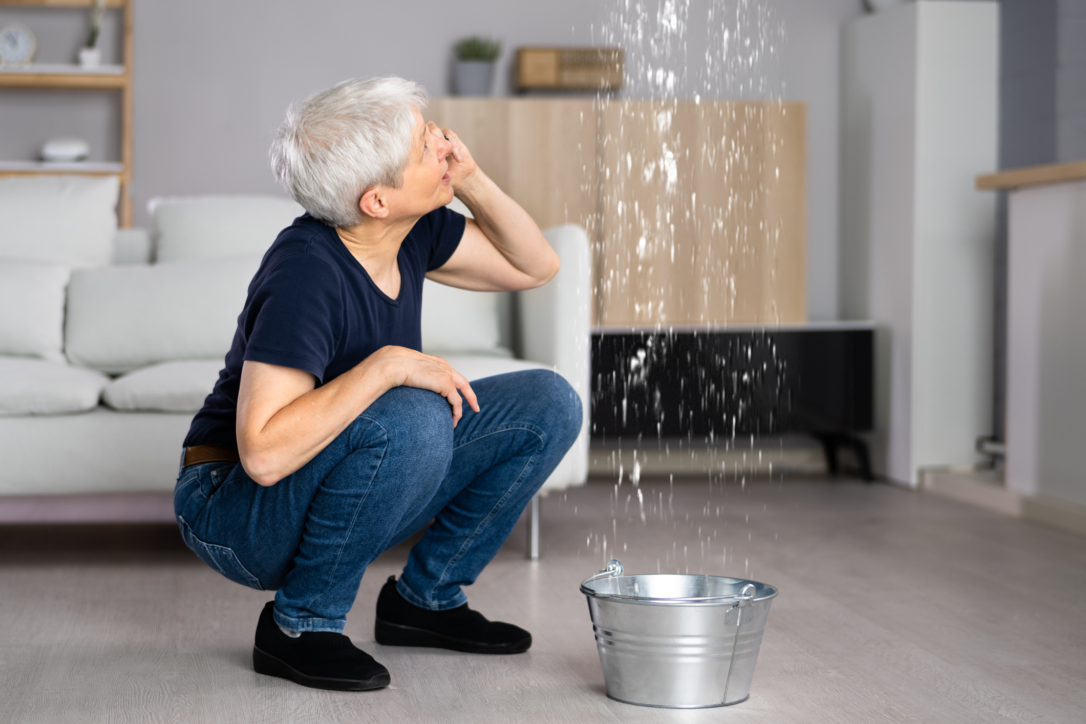 Woman Calling Plumber with Water Leaking from Ceiling